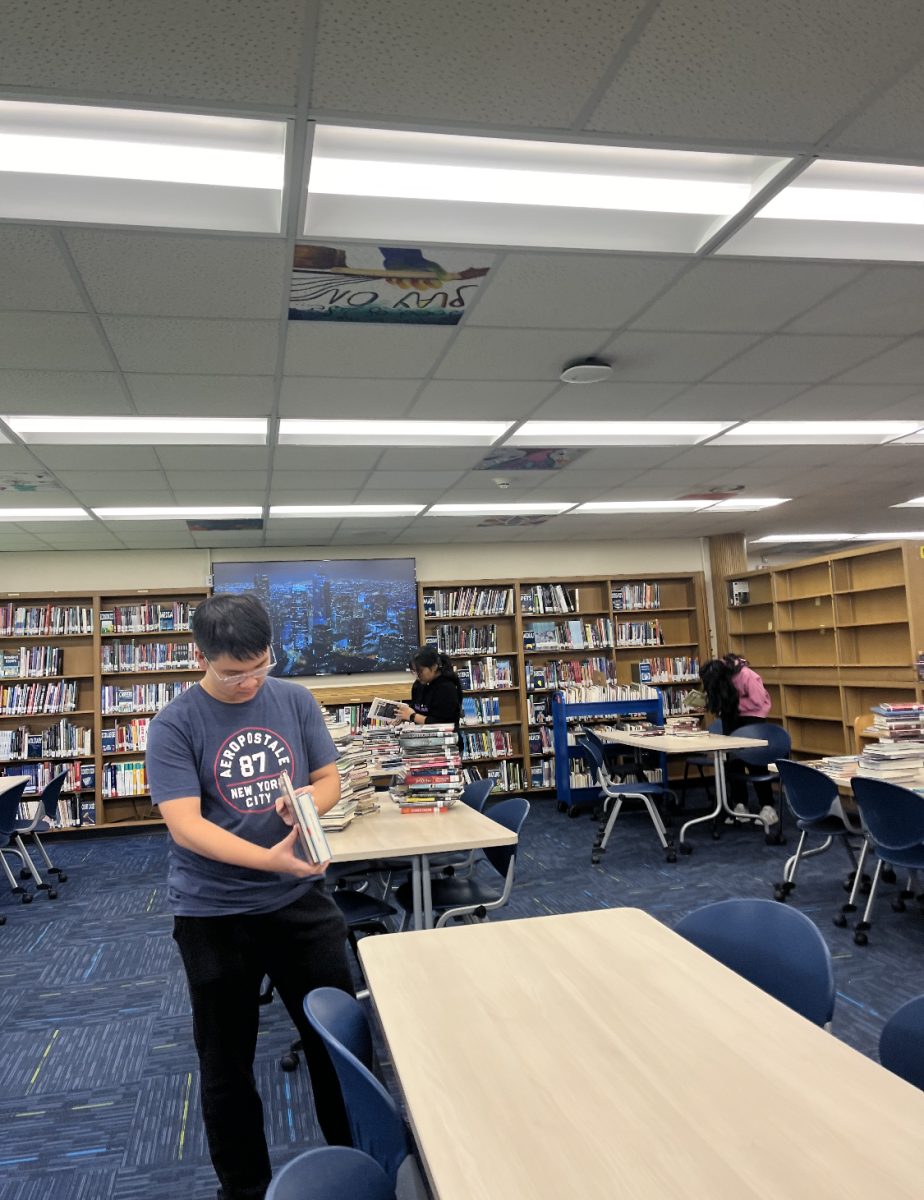 National English Honor Society members assist in reshelving the library.