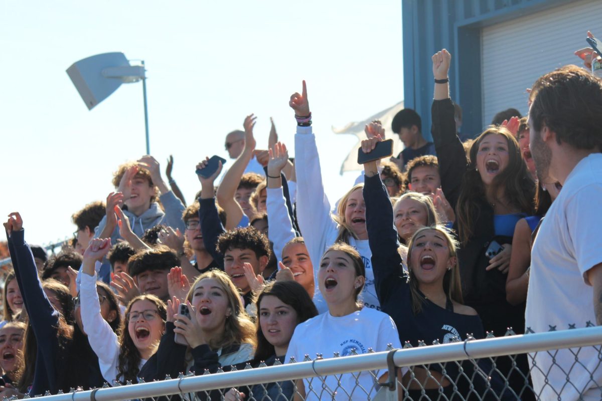 Students cheer during the first touchdown of the Homecoming game.