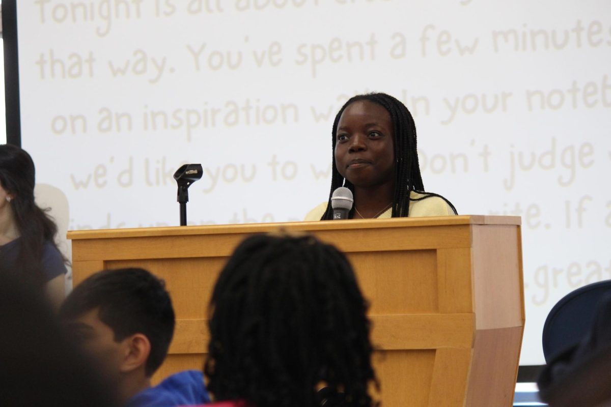 National English Honor Society President Deborah Aderibigbe introduces the student poets. 