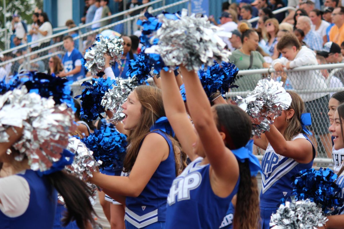 The Varsity Cheer team cheers on the football team.