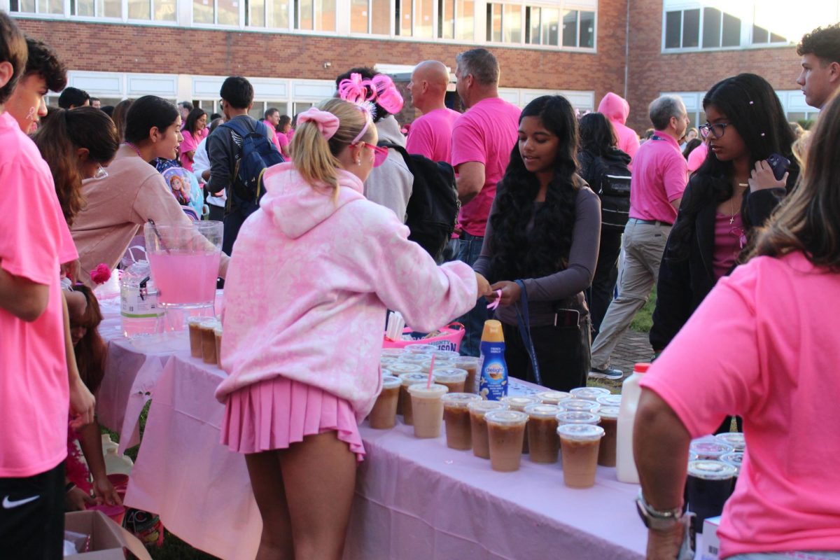 The business department sell pink lemonade and iced drinks for the Pink Bagel Sale.