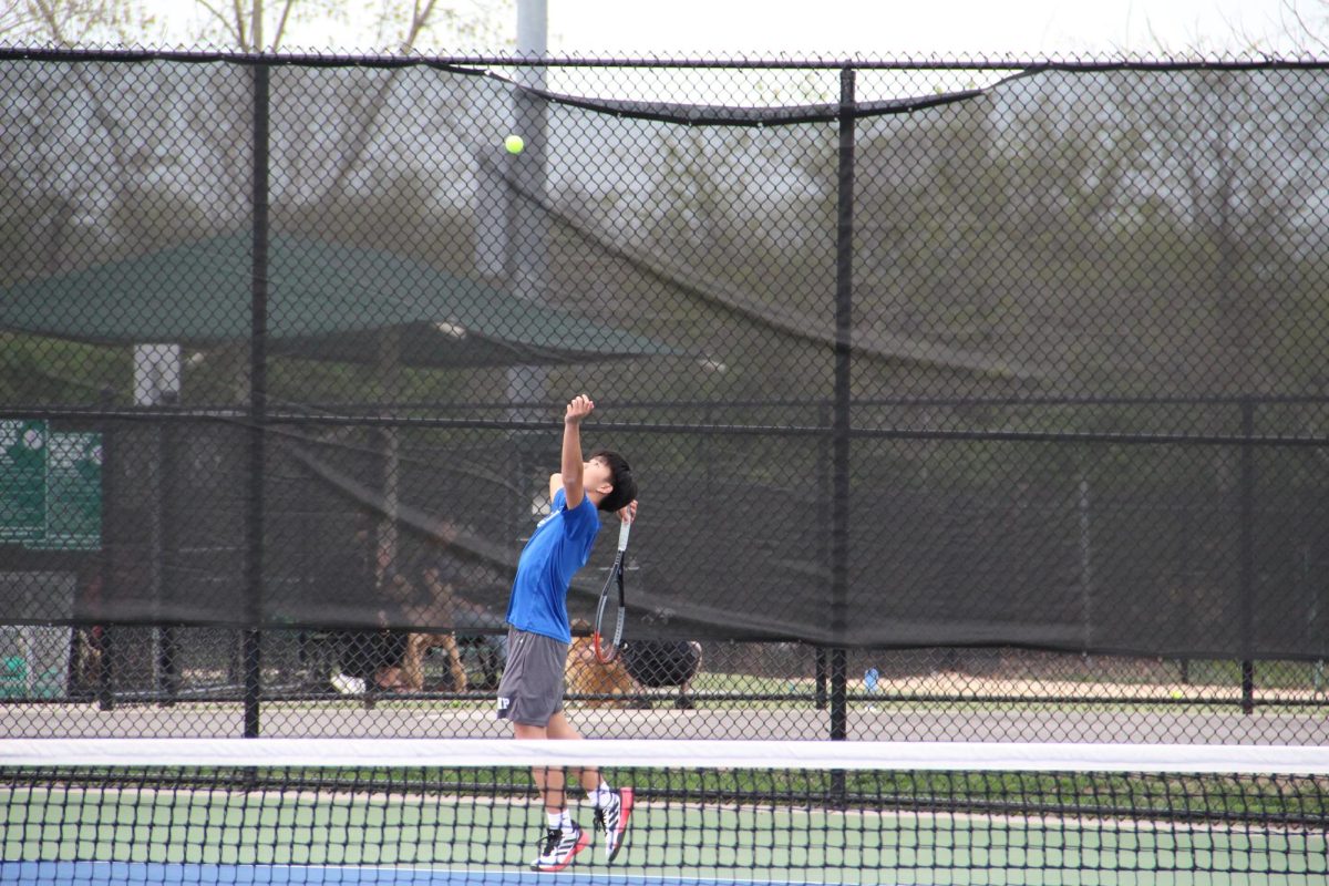 Senior Andrew Tso serves in tennis. 